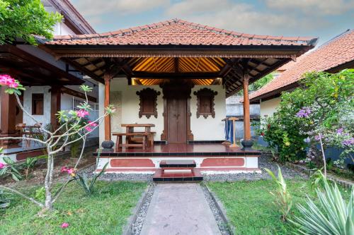 a house with a pavilion in a garden at Ganesh Beach Hotel in Candidasa