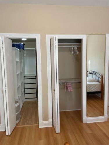 a room with two open doors and a bedroom at Rose Garden Vancouver in Richmond