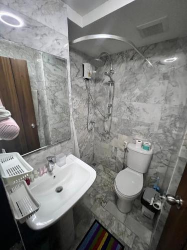 a bathroom with a white sink and a toilet at Mai Khao Serenity in Ban Mai Salae