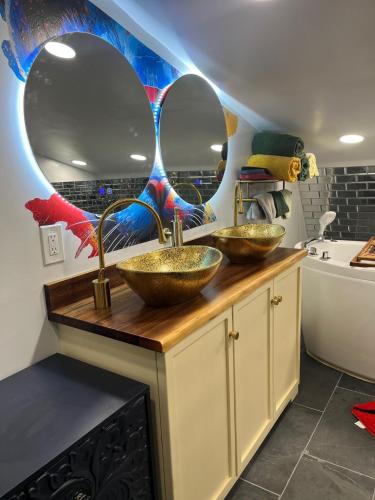 two sinks in a bathroom with two mirrors at Paloma, Large Attic Apartment in Shandaken