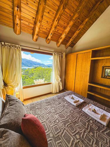 a bedroom with a bed and a large window at Paraiso de Montaña in Villa Pehuenia