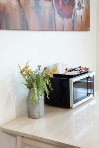 a vase of flowers sitting on a table next to a microwave at Pemberton Hotel (Motel) in Pemberton