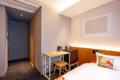 a hotel room with a bed and a desk at Hotel Ethnography Kiyomizu Gojo in Kyoto