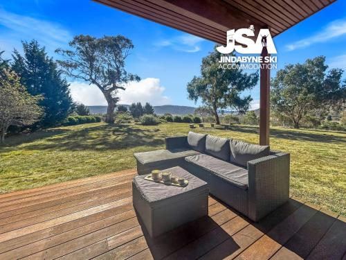 a couch on a deck with a view of a field at The Orchard in Moonbah