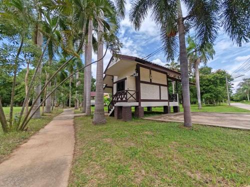 a small building with palm trees in a park at RS Phong Riverside Resort in Khon Kaen