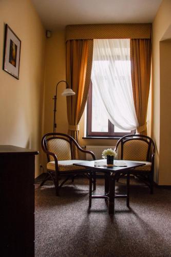 a living room with a table and chairs and a window at Pensjonat Lorien in Szczawno-Zdrój