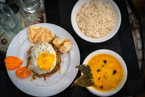 two plates of food with eggs and rice on a table at Thundi Village & Spa in Maalhos