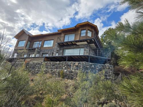a house on top of a stone wall at Vistas a las Montañas in San Martín de los Andes