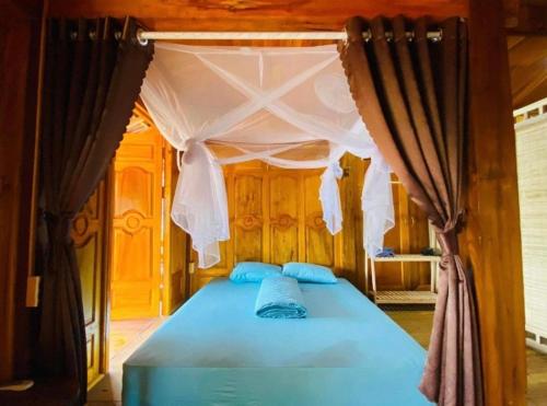 a bedroom with a blue bed with a canopy at Cao bành Homestay in Ha Giang
