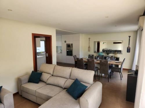 a living room with a couch and a dining room at Casa Rogel by Armação de Pêra with Heated Pool and Games Room in Alcantarilha