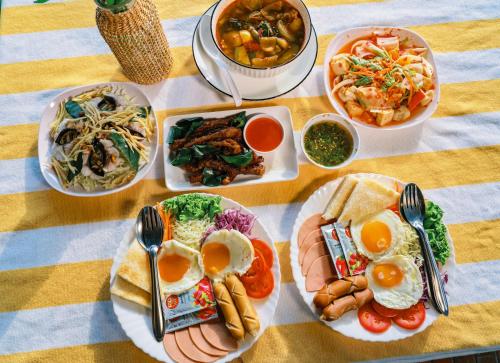 The Good View Erawan Resort في Tha Kradan: طاولة عليها أطباق طعام