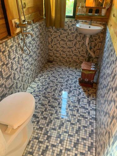 a bathroom with a toilet and a sink at Năm mùa Bungalows in Hương Hóa