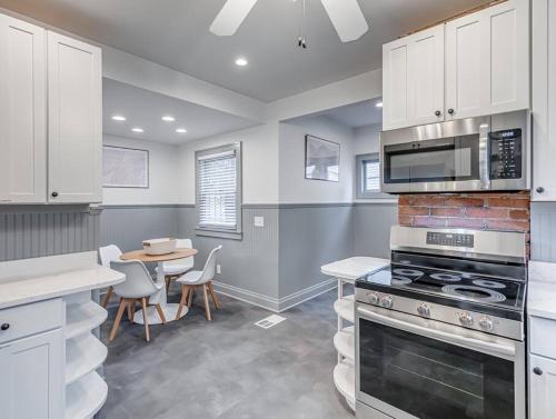 a kitchen with a stove and a table with chairs at Upscale Historic Home near Downtown, Hall of Fame, Beach, Arenas in Cleveland