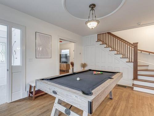 a pool table in a room with a staircase at Upscale Historic Home near Downtown, Hall of Fame, Beach, Arenas in Cleveland