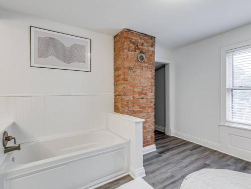 クリーブランドにあるUpscale Historic Home near Downtown, Hall of Fame, Beach, Arenasのレンガの壁のバスルーム(バスタブ付)