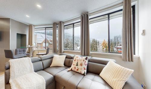 a living room with a couch and some windows at Whistler village central stay! in Whistler