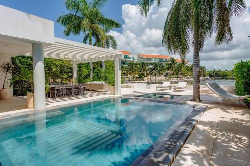 a swimming pool at a resort with palm trees at Dream House with private Deck in Puerto Aventuras in Puerto Aventuras