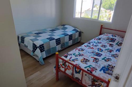 a bedroom with two beds and a window at Casa acogedora puertas del Mar in La Serena