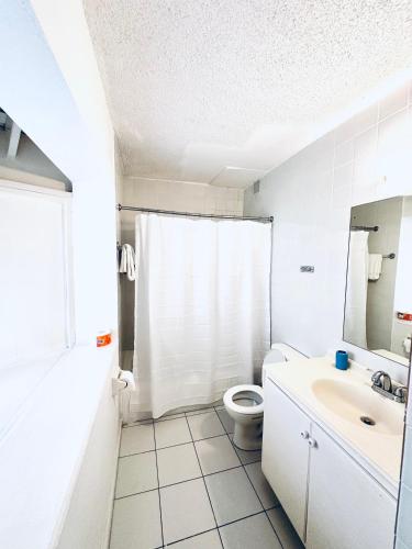 a white bathroom with a toilet and a sink at Mystical Studios King in Ocho Rios