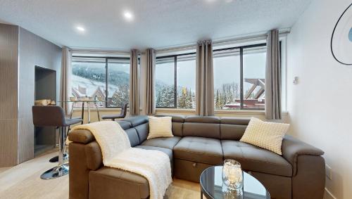 a living room with a couch and a large window at Whistler village central stay! in Whistler