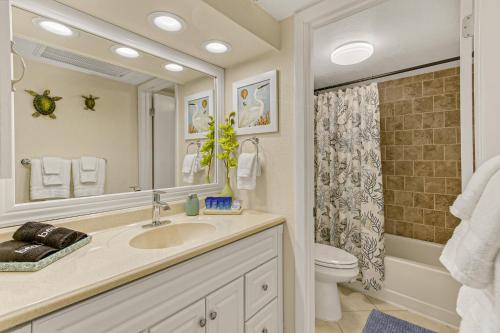 Un baño con lavabo, inodoro y espejo. en Haven Harbor Getaway, en Melbourne