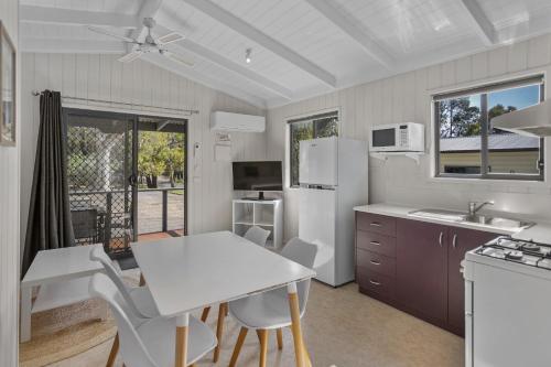 Una cocina con una mesa y un refrigerador blanco. en Pet Friendly On The Great Ocean Road, en Aireys Inlet