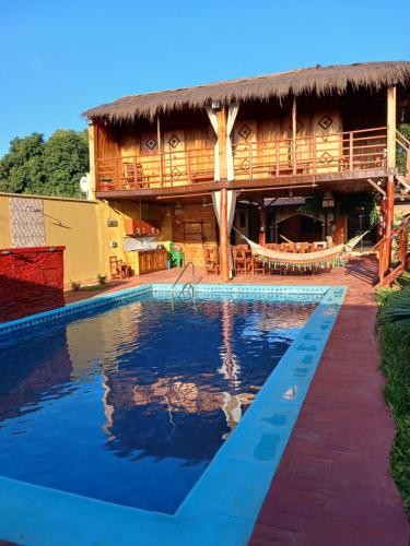 a resort with a swimming pool in front of a building at Cabañas Compartidas en Casa Quinta en Itá in Itauguá