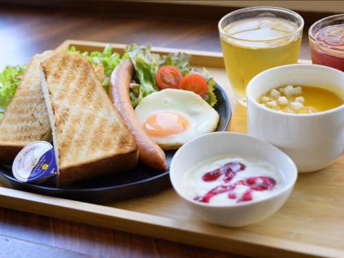 a tray with a plate of breakfast food with eggs and toast at HOTEL THE CUBE Naha Kokusai Street in Naha
