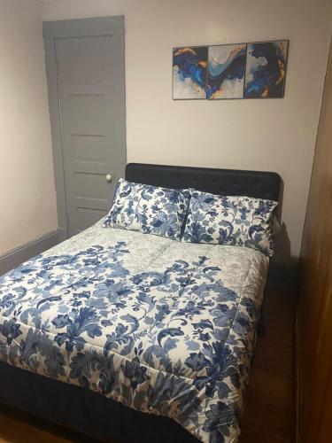 Un dormitorio con una cama con un edredón azul y blanco. en Casa localizada muy cerca del estadio, 8 minutos del centro y muchos lugares mas, No se permiten fiestas , o fumar, en Milwaukee