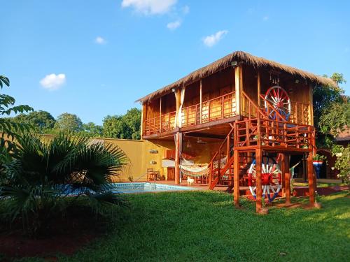 a large building with a wheel in the grass at Cabañas Compartidas en Casa Quinta en Itá in Itauguá