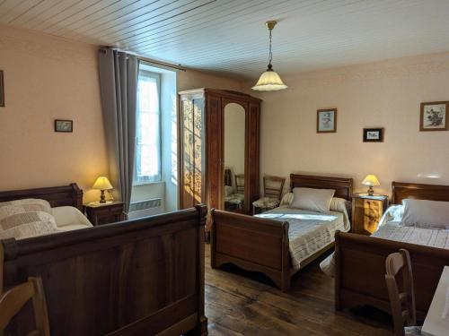 sypialnia z dwoma łóżkami i lustrem w obiekcie Gîte familial avec jardin au bord de l'eau, terrasses, vélo, jeux, proche Charente, WiFi inclus - FR-1-653-189 w mieście Saint-Genis-dʼHiersac