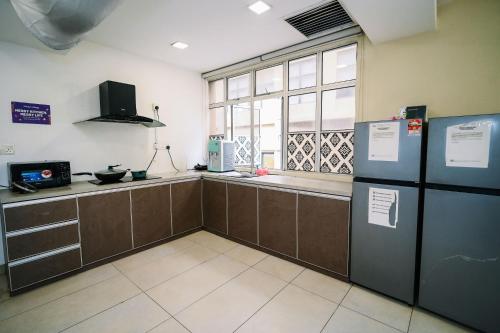 a kitchen with brown cabinets and a large window at Swing & Pillows - USJ Taipan in Subang Jaya