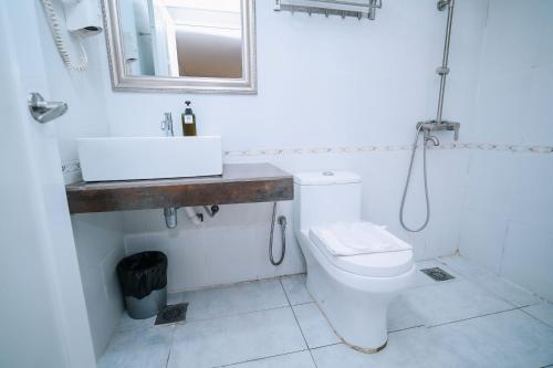 a bathroom with a toilet and a sink and a mirror at Swing & Pillows - USJ Taipan in Subang Jaya