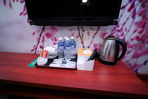 a table with a coffee pot and water bottles on it at Swing & Pillows - USJ Taipan in Subang Jaya