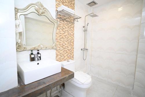 a bathroom with a sink and a toilet and a mirror at Swing & Pillows - USJ Taipan in Subang Jaya