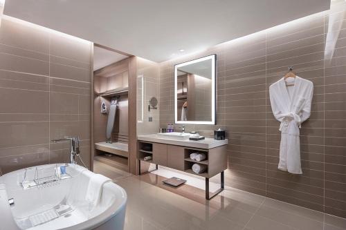 a bathroom with a tub and a sink and a bath tub at Holiday Inn Tianjin Wuqing by IHG in Wuqing