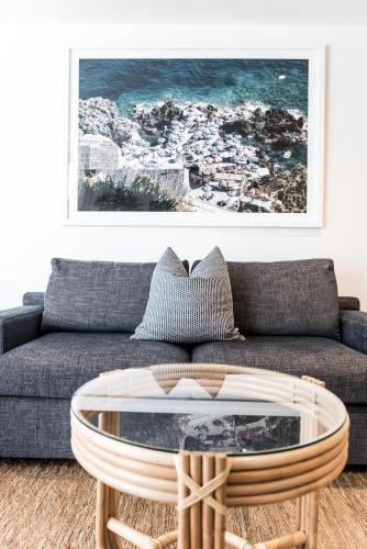 a living room with a couch and a coffee table at On The Beach Noosa Resort in Noosa Heads