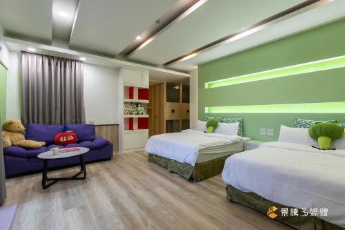 a bedroom with two beds and a blue couch at ChaoPingJia Homestay in Luodong