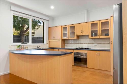 a kitchen with wooden cabinets and a counter top at Bobby's Beachside Bungalow in Grange in Grange