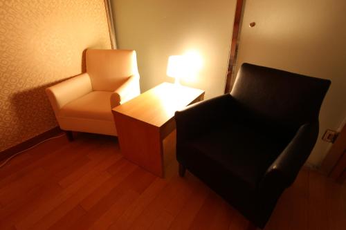 a room with a chair and a table and a lamp at Prince Hotel in Seoul