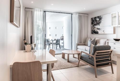 a living room with a table and a couch at On The Beach Noosa Resort in Noosa Heads