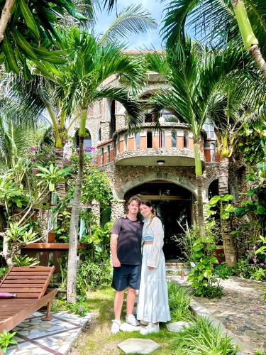 a man and a woman standing in front of a building at Sầm Sơn Boutique Hotel Phan Thiết in Phan Thiet