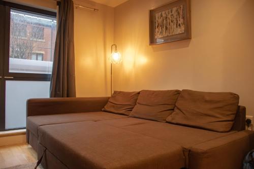 a couch in a living room with a window at The Chandler Apartments in Leeds