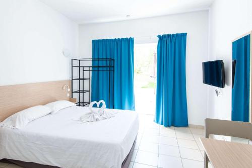 a bedroom with blue curtains and a bed and a table at Comfort Aparthotel Frejus La Tour de Mare in Fréjus