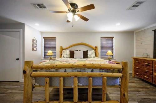 a bedroom with a wooden bed with a ceiling fan at Diamond in the Ruff Hot Tub in Broken Bow