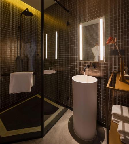 a bathroom with a sink and a tub and a shower at Tan Alley Wuzhen Eco and Cultural Community in Tongxiang