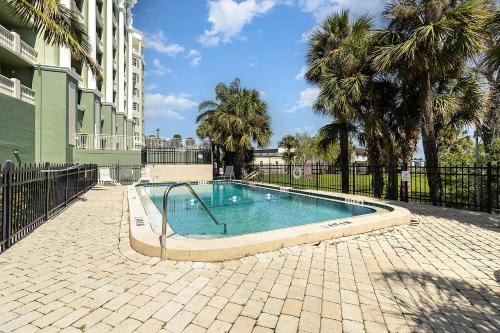 a swimming pool with a fence and palm trees at Haven Harbor Getaway in Melbourne