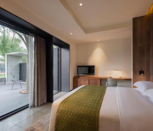 a bedroom with a large bed and a balcony at Tan Alley Wuzhen Eco and Cultural Community in Tongxiang