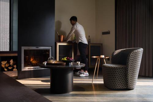 a man standing in a living room with a fireplace at Tan Alley Wuzhen Eco and Cultural Community in Tongxiang