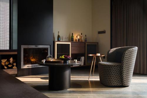 a living room with a fireplace and a table and a chair at Tan Alley Wuzhen Eco and Cultural Community in Tongxiang